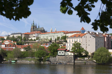 Spring green Prague Lesser Town with gothic Castle above River Vltava in the sunny Day, Czech Republic