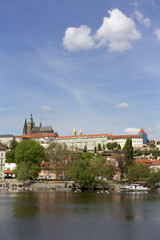 Obraz premium Spring green Prague Lesser Town with gothic Castle above River Vltava in the sunny Day, Czech Republic