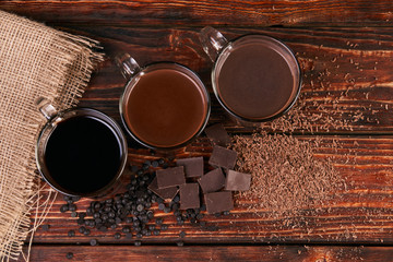 Glasses of chocolate milkshake on wooden table closeup, sweet dessert food 