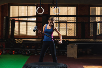 Young woman hammering large tire at gym © o_lypa