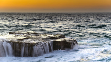 Sunrise Seascape with Cascades over the Rock Ledge