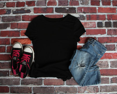Mockup blank black t shirt with jeans and shoes on brick background