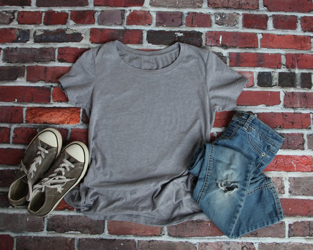 Mockup blank gray t shirt with jeans and shoes on brick background