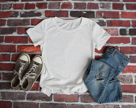 Mockup blank white t shirt with jeans and shoes on brick background