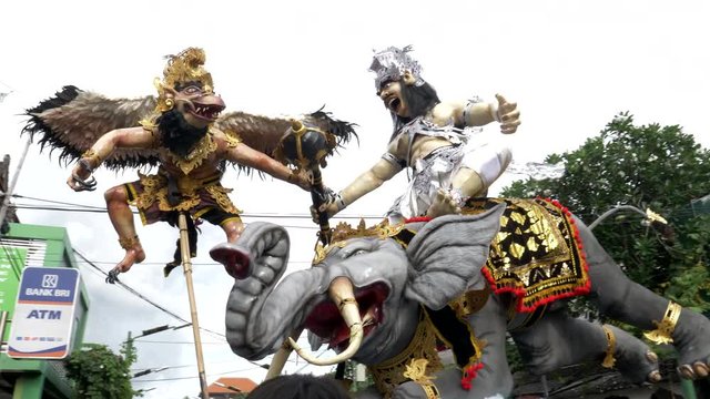 tracking shot of an ogoh-ogoh being moved on a kuta street of bali for a nyepi parade