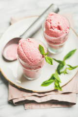 Healthy low calorie summer dessert. Homemade strawberry yogurt ice cream in glasses over light grey marble table background, selective focus. Clean eating, dieting food concept