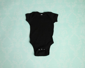 Mockup of blank black baby bodysuit tshirt on aqua background