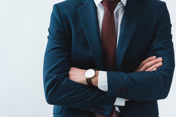 cropped shot of businessman in formal wear standing with crossed arms