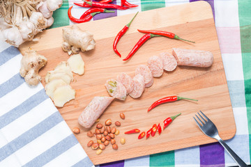 Thai fresh sour pork (Nham) on a wooden Chopping board, traditional Thai style food. Serve with beer.