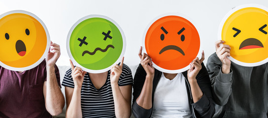 Diverse people holding emoticon
