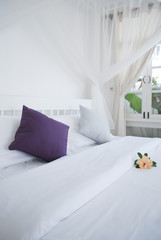Colorful pillows on white bed