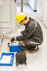 Electrician engineer tests system with relay test set equipment