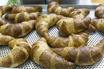 Croissants on a basket weave in a bakery shop.