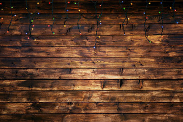 Brown wooden background with christmas lights.