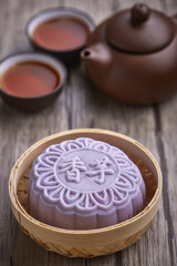 Chinese mid autumn festival foods. Snow skin mooncake on wooden table with text Purple 