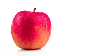 A red apple with water drops on skin isolated on white background with copy space. Healthy fruit and healthy food concept. Vegan food.