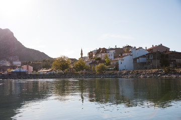 Fototapeta premium traditional buildings reflected in calm water, mountains and coast, lake egirdir, turkey