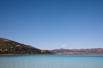 Fototapeta premium beautiful landscape with calm water and mountains on shore at sunny day, salda golu, turkey