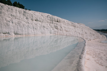 spectacular view of famous white rocks reflected in water of pool, pamukkale, turkey