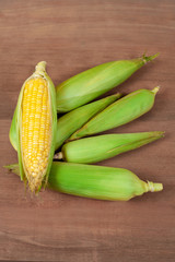 Organic fresh Corncobs or corn ears on wood background ,food