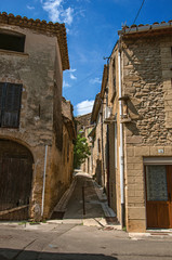 Fototapeta na wymiar Street view with stone houses in the city center of Chateauneuf-du-Pape hamlet. Near Avignon, Vaucluse department, Provence region, southeastern France
