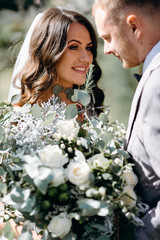 The first meeting of the bride and groom on their wedding day in the garden. Waiting and emotions of the newlyweds. The first kiss of the bride and groom
