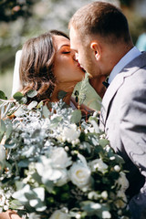 The first meeting of the bride and groom on their wedding day in the garden. Waiting and emotions of the newlyweds. The first kiss of the bride and groom