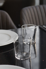 White plates, glasses and utensils on black table, elegant tableware