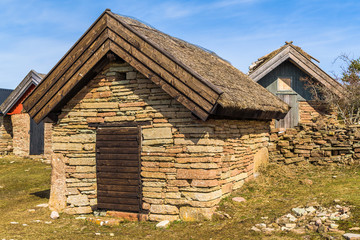 Obraz premium Fishing cabin made of stacked limestone slabs and thatched straw roof at the historic fishing village of Bruddesta on Oland, Sweden.