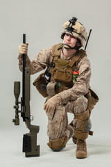Soldier in camouflage holding rifle