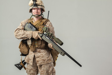 Soldier in camouflage holding rifle