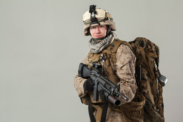 Soldier in camouflage holding rifle