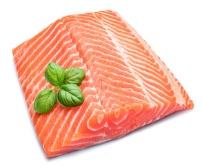 Fresh raw salmon fillet decorated with basil leaves.