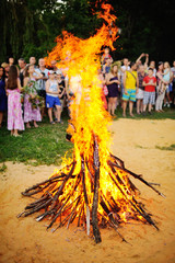 Large Bonfire on the background of people. The celebration of Ivan Kupala