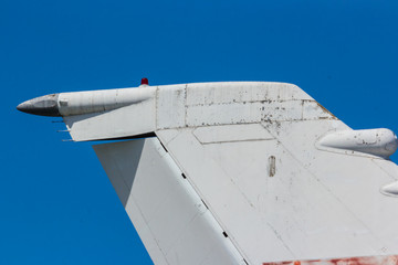 Tail of a modern plane with old abandoned plane in background