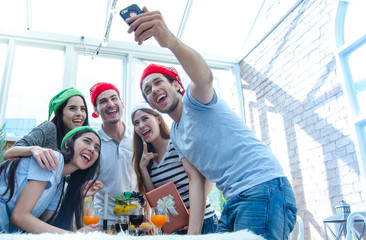 Group of friends shooting selfie and having fun in party time, with Christmas hat
