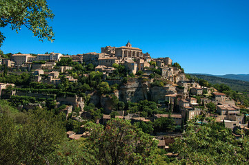 Obraz premium Panoramic view of the village of Gordes on top of a hill and under sunny blue sky. Located in the Vaucluse department, Provence region, in southeastern France