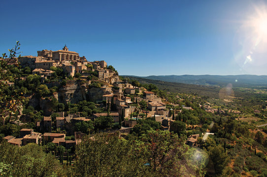 Panoramic view of the village of Gordes on top of a hill and under sunny blue sky. Located in the Vaucluse department, Provence region, in southeastern France. Retouched photo