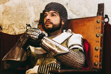 Medieval templar soldier sitting on a throne.
