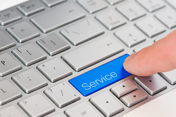 A finger press blue Service button on laptop keyboard