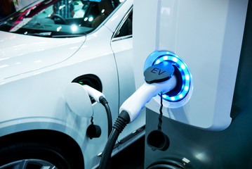 Power supply connect to electric vehicle for charge to the battery. Charging technology industry transport which are the futuristic of the Automobile.EV fuel Plug in hybrid car. - obrazy, fototapety, plakaty