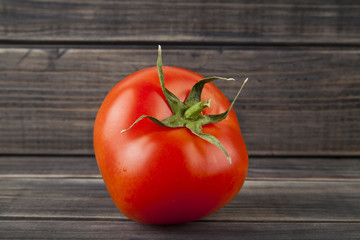 red, juicy, fresh tomatoes on a wooden background