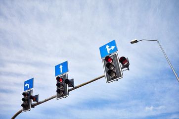 Traffic lights with countdown timers, red color displayed against the blue sky, space for text.