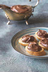 Slices of baguette with chocolate cream on the plate