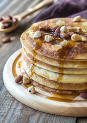 Stack of pancakes with maple syrup and nuts