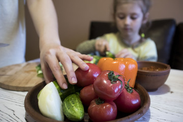 mom and daughter cut salad in the kitchen