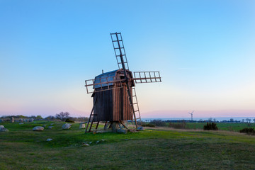 En gammal trä väderkvarn på Öland Sverige i kvällsljus med havshorisonten i bakgrunden