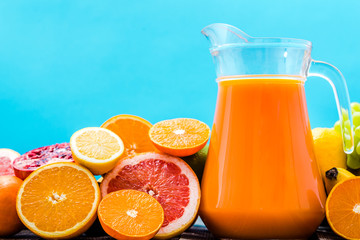 Fresh squeezed juice in pitcher, beverage with blend orange and tropical fruits on table