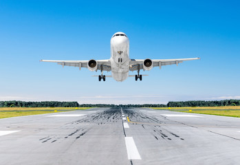 Fototapeta na wymiar Passenger airplane landing at in good clear weather with a blue sky on a runway.
