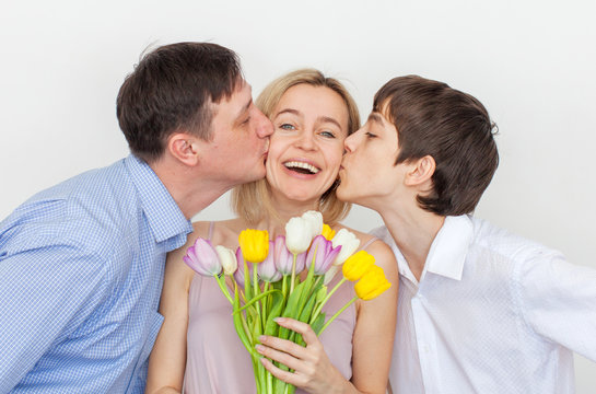 Man and son gives a bouquet of flowers to woman